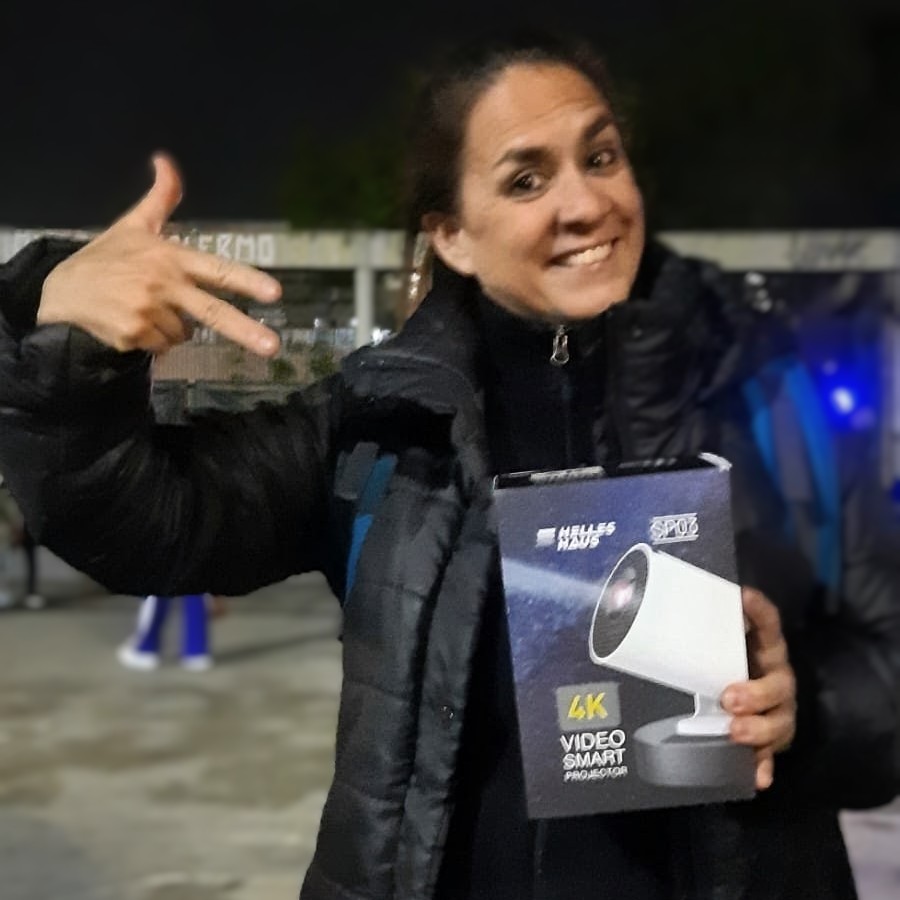 Mujer feliz con la caja de un proyector portátil